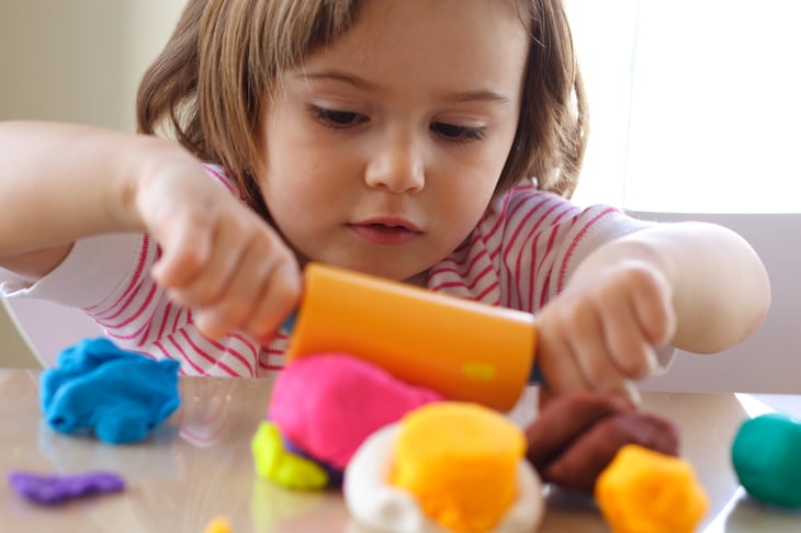 Little girl playing with play dough