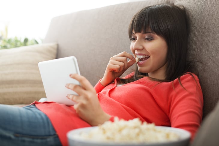 Woman eating popcorn, watching a show