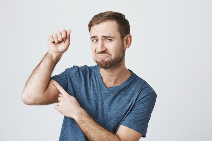 Man points to bicep