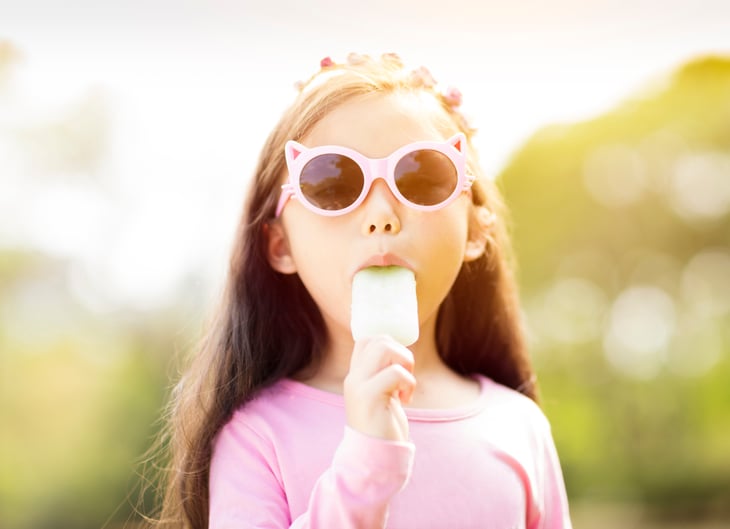 Young girl eats a popsicle