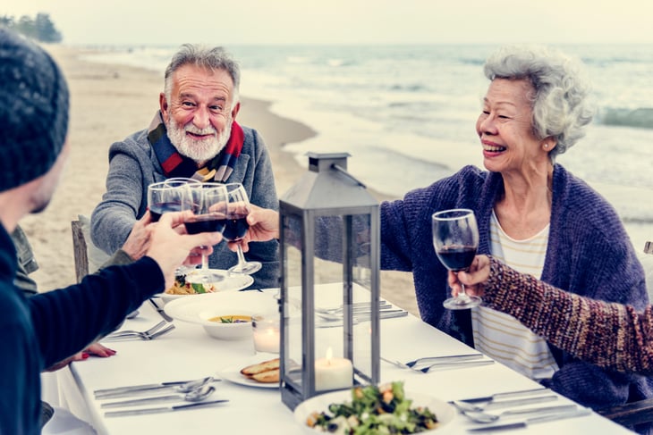 Seniors family toast at a beach party