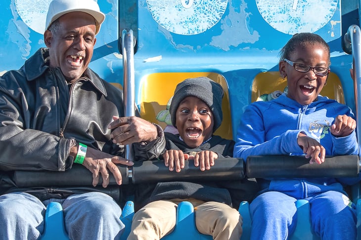African American grandfather and kids on ride at the fair, Alabama