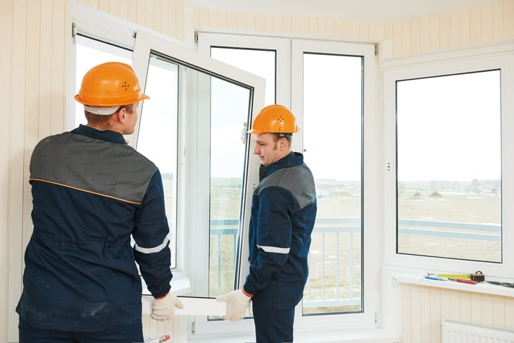 Workers installing windows in a home