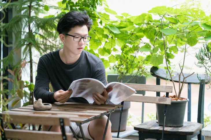 A young man reads a magazine