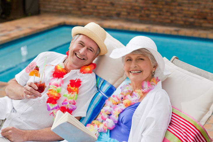 Older couple with leis sitting poolside