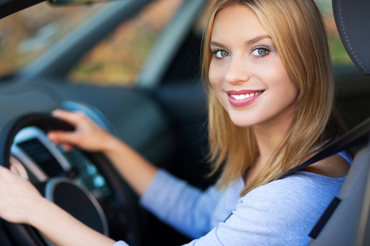Smiling woman sitting in car