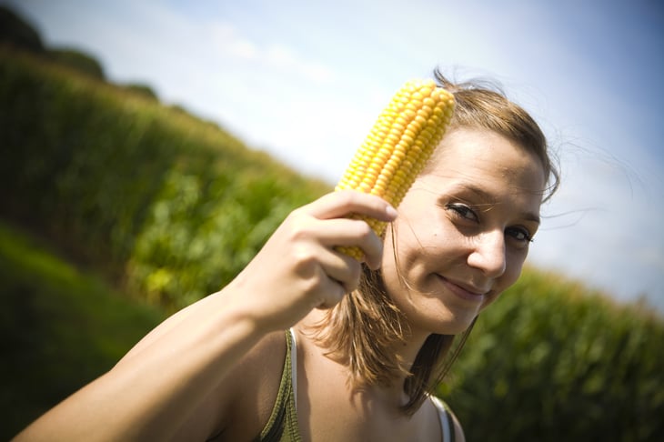 Woman holding an ear of corn