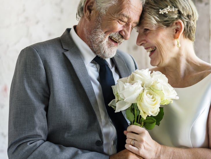 Older bride and groom with floral bouquet