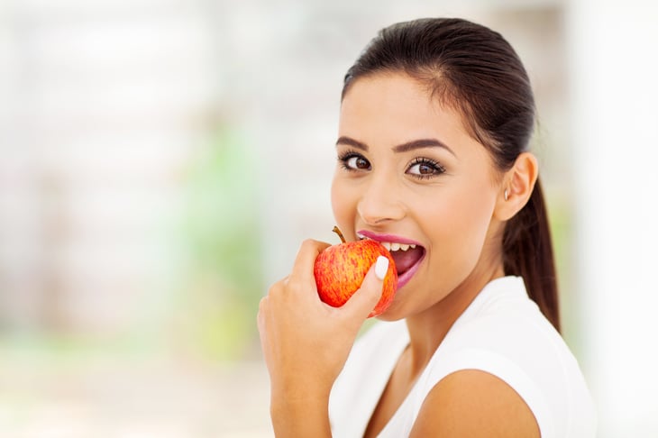 Young woman eating an apple