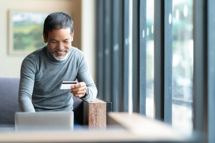 Retired man Happy mature with urban lifestyle man holding credit card paying online laptop payment. Asian senior male smiling shopping online