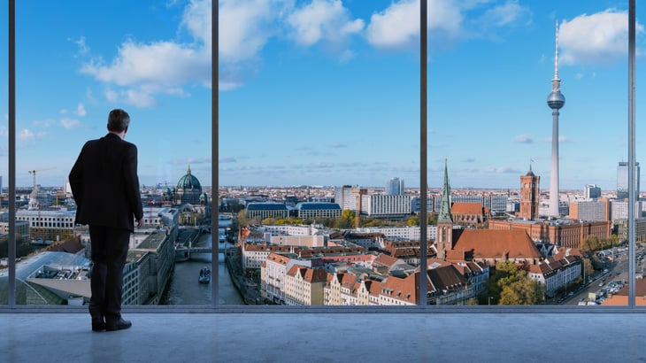 Business man in a loft looking at skyline of Berlin in Germany
