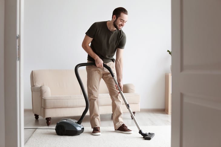 A man vacuums his home