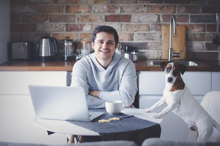 Man working from home, with dog.