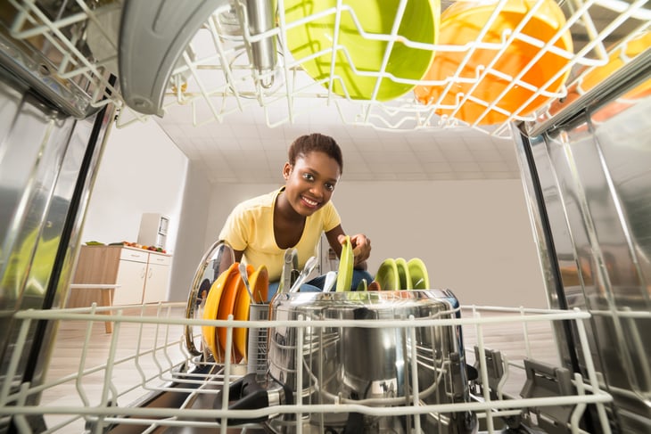 Woman looking in a full dishwashere