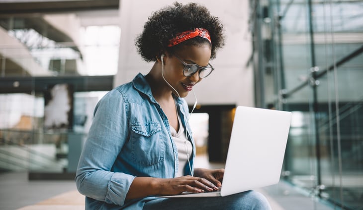 african american female university student sitting campus laptop