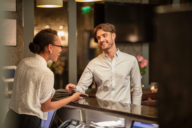 Man checking into hotel with credit card rewards