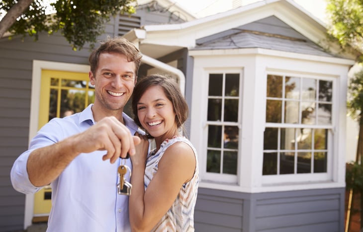 Couple standing in front of a home