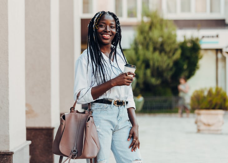 A woman walks with a cup of coffee