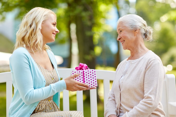 A daughter gives a gift to her mother