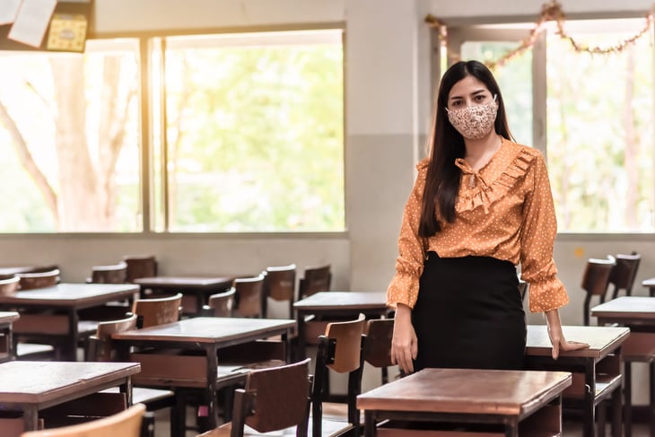 A female teacher in an empty classroom during the pandemic