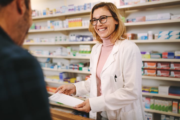 Pharmacist taking a prescription from a customer