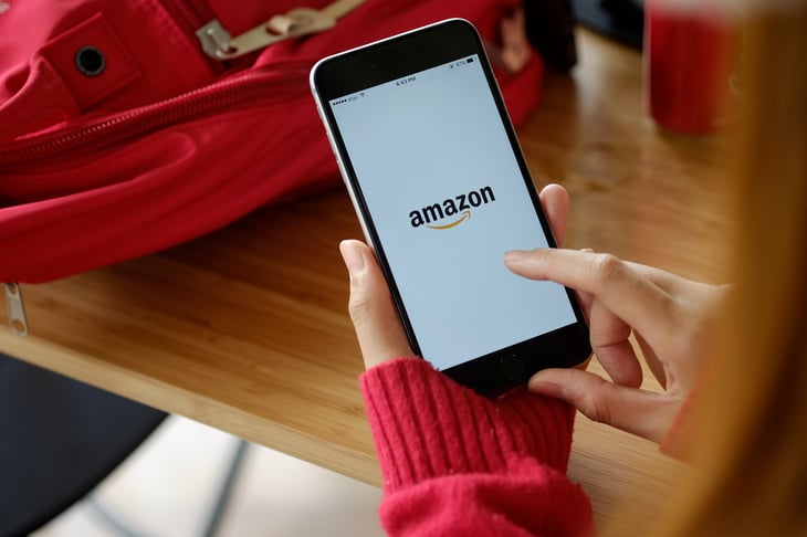 A woman uses the Amazon app to shop on her smartphone