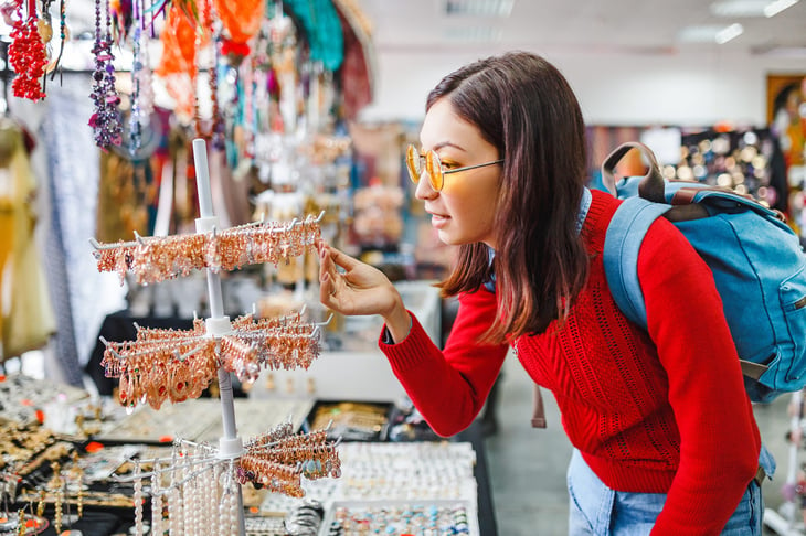 woman looking for fancy jewelry and accessories in a flea market shop