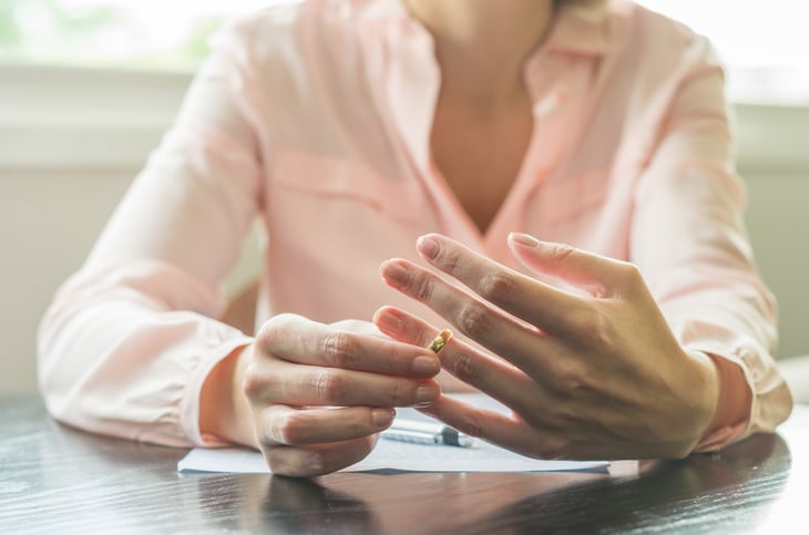 A woman removes her wedding ring during a divorce