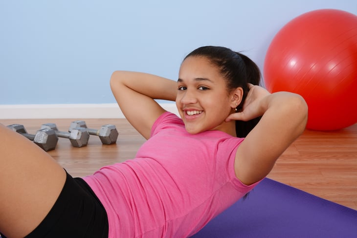 Teen girl working out in the gym