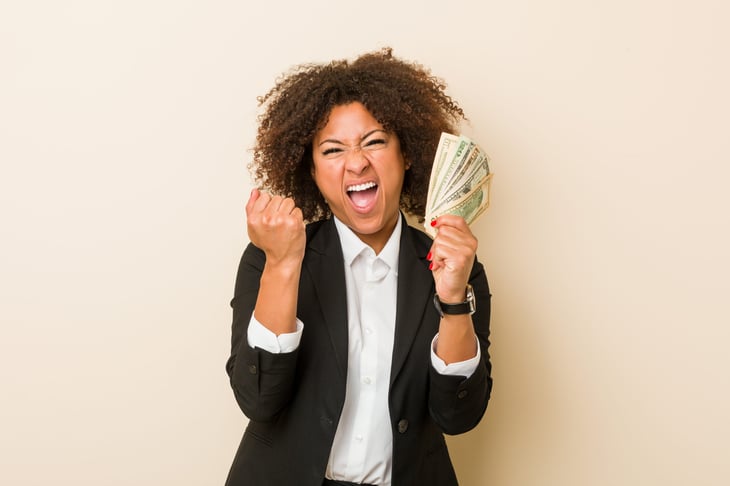 Excited businesswoman with cash