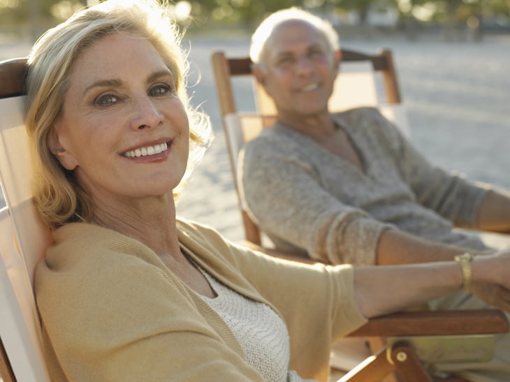 An older couple relaxes on the beach