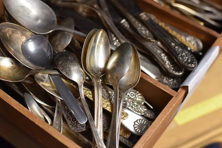 Antique silverware piled in a drawer