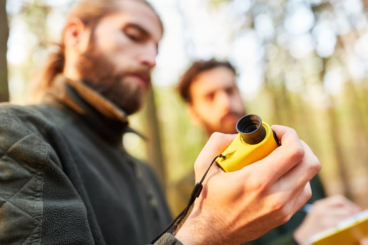 By Robert Kneschke Royalty-free stock photo ID: 1418174957 Two men foresters rangefinder to measure the height of the tree