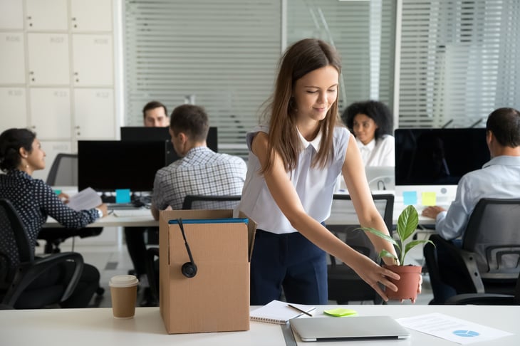 Smiling hired young woman company employee unpacking box new job shared office intern or newcomer new job start work