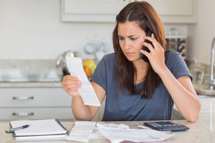 Woman on the phone regarding a bill and fees