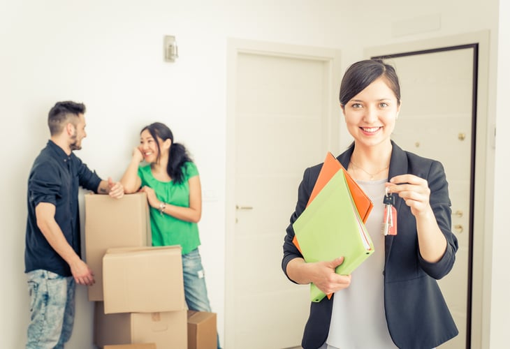 real estate agent woman with clients in new home keys