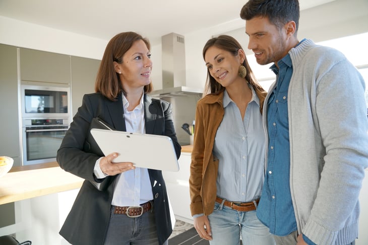 Couple with real-estate agent visiting house for sale