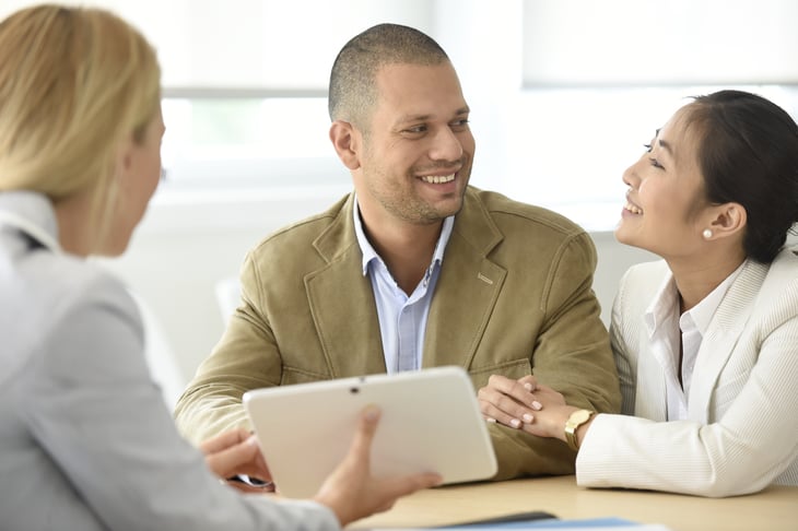 Insurance broker or salesman making offer to young millennial couple using laptop in cafe, realtor consulting customers about mortgage sitting at coffeehouse table pointing on computer screen