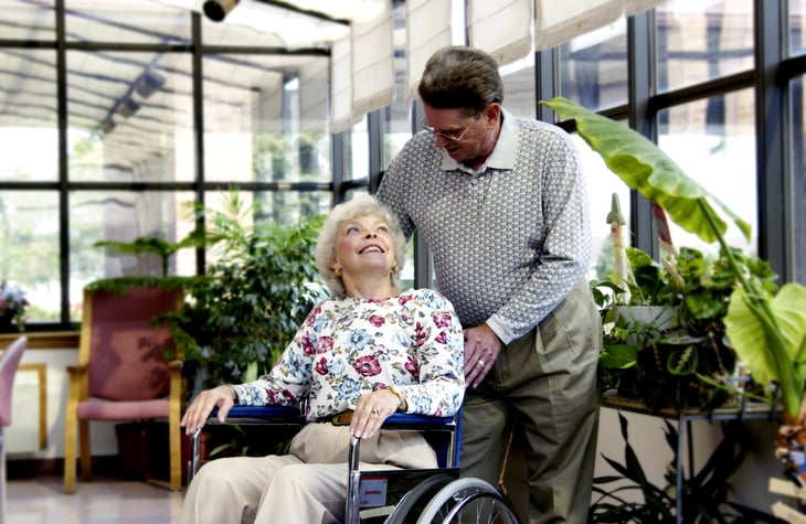 Man pushing a woman in a wheelchair