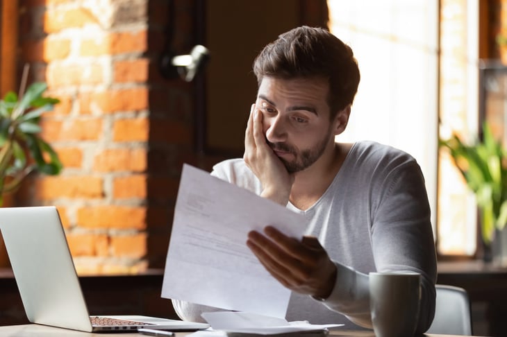 sad man reading his credit report