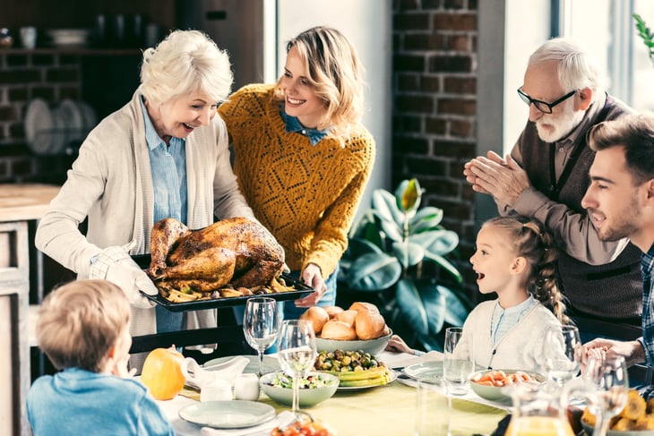 Family serving Thanksgiving dinner.