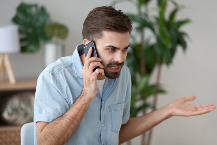 An annoyed man argues on the phone