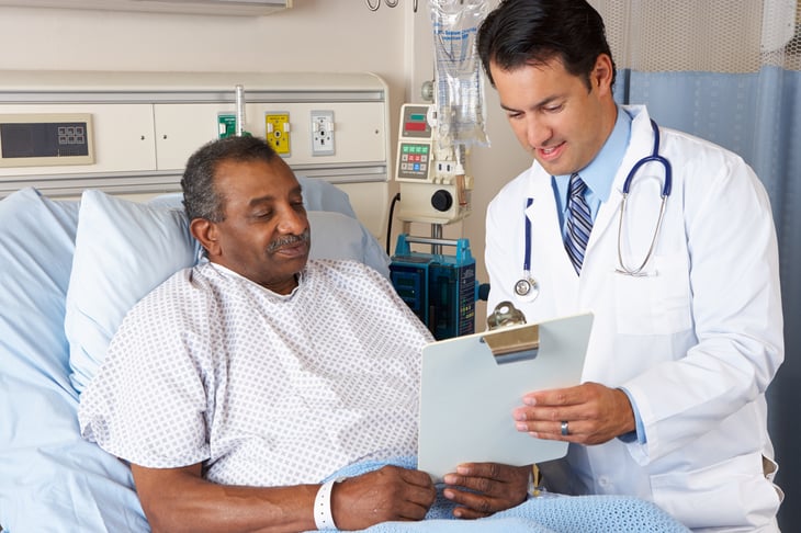 A doctor visits an older patient in the hospital