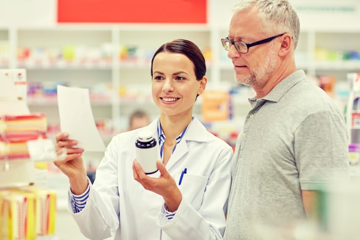 Pharmacist helping a senior with a prescription