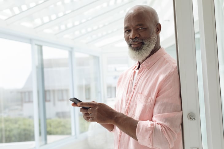 A senior black man uses a smartphone