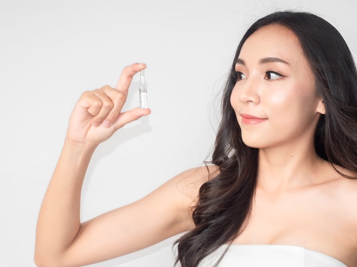 woman girl holding hair serum bottle.