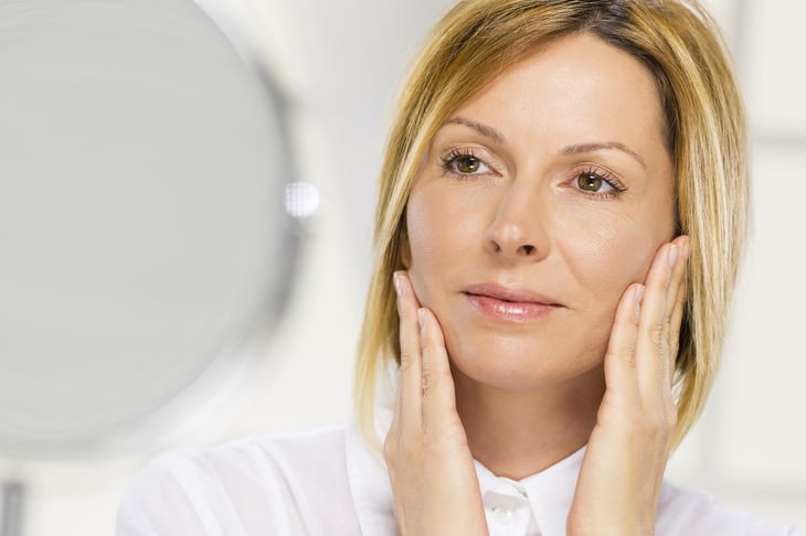 Woman applying cosmetics to her face