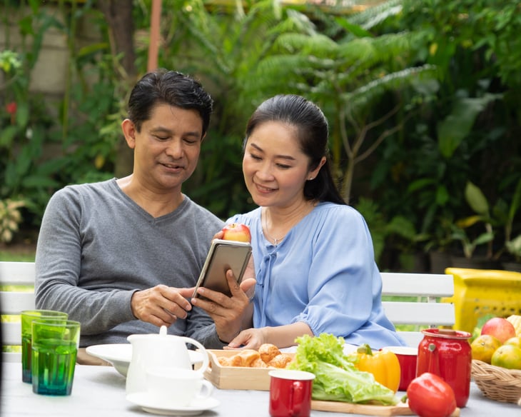Asian senior man woman couple looking at phone home garden
