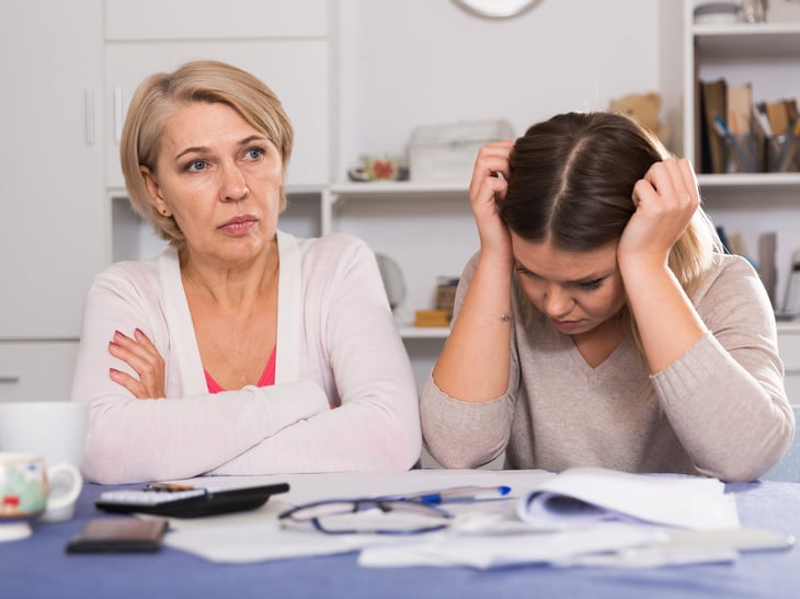 Mother and her adult daughter head in hands money trouble finances debt problems