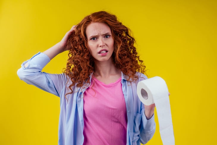 Upset woman holding cheap toilet paper